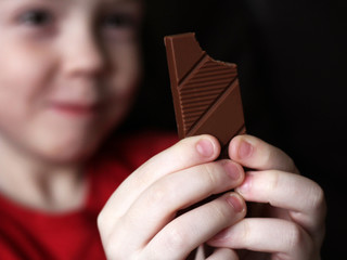 Little cute kid eating chocolate