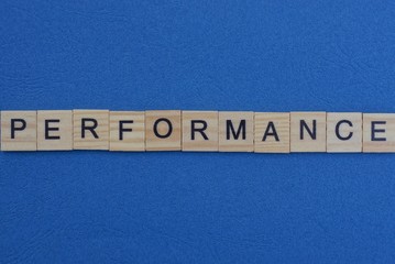 word performance from small gray wooden letters lies on a blue background
