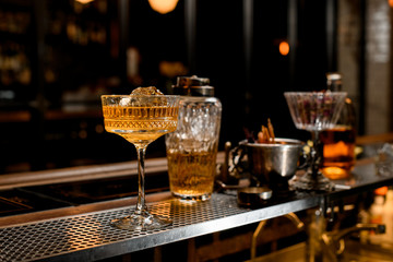 beautiful view of bar on which stands glass with brown alcoholic drink.