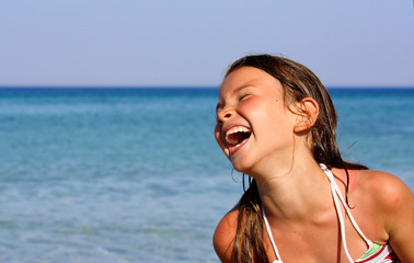 BAMBINA IN SPIAGGIA RIDENDO