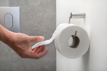 A hand reaching for toilet paper