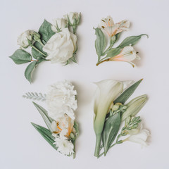 Creative Easter layout with flowers and leaves on white paper background. Spring Easter holiday...