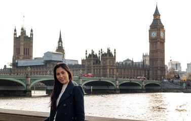 Asian business women near Big Ben, London, England. Girl in London during winter near Westminster bridge, London. oung female travel  in London, England. Beautiful young Asian girl. 