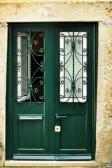 Green damaged wooden door with door knocker