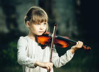 beautiful girl plays the violin in nature