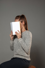 Happy world book and copyright day, read to become someone else - woman covering face with book...
