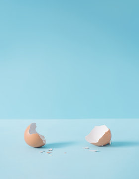 Empty eggshell with creative copy space on pastel blue background. Minimal Easter holiday concept.
