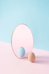 Creative Easter concept with egg and mirror on pastel pink and blue background. Minimal Easter Holiday idea. - 332906031