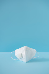 Respiratory or surgical face mask. Coronavirus or COVID-19 protection on blue background. Pandemic...