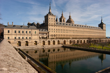 Fototapeta na wymiar Vista de la fachada sur del Real Monasterio de San Lorenzo de El Escorial reflejada en el estanque.