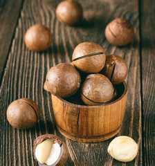 Macadamia nuts on a wooden background. The concept of a healthy diet and natural skin care.