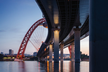 Sunset view of Picturesque bridge with big red arch over the Moscow river, Moscow, Russian Federation.