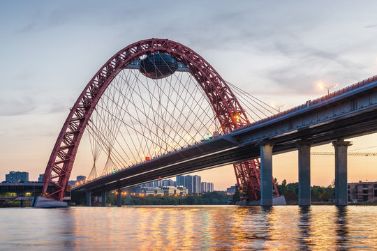 Sunset view of Picturesque bridge with big red arch over the Moscow river, Moscow, Russian Federation.