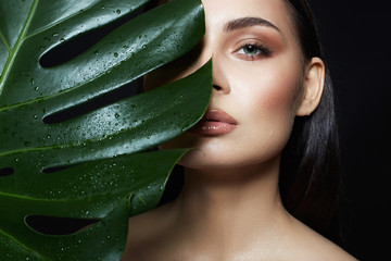 beautiful wet girl in palm leaves. Natural cosmetics