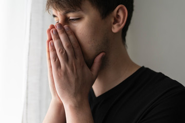 Young man coughing into his arm or to prevent spread virus, close-up