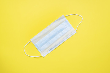 Disposable medical face masks. The concept of prevention of the virus. Yellow background. Copy space.