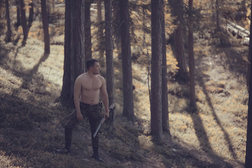 hunting man / hunter with a gun hunting in the autumn forest, yellow trees landscape in the taiga