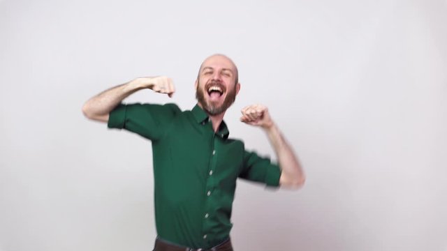 Happy man dancing and celebrating a victory over white background. Emotions of success, triumph, victory and winning.