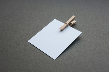White blank and empty paper with wooden clip, close up from a sheet for a message, mock up, no people, horizontal