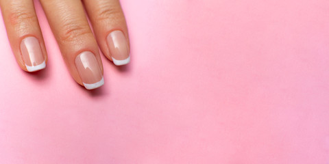 female fingers with beautiful manicure on a pink background. high resolution widescreen image. copy space