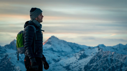 Man walking on top of a mountain, sunrise