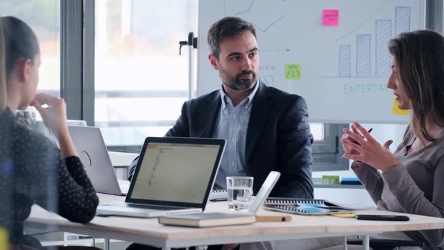 Video of business people discussing together in conference room during meeting at office.