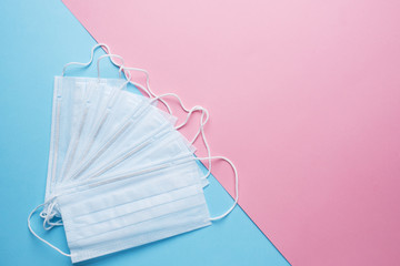 Disposable medical face masks. The concept of prevention of the virus. Pink blue background. Copy space.