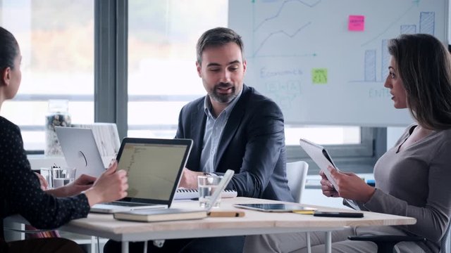 Video of business people discussing together in conference room during meeting at office.