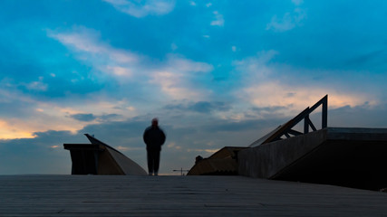 Silhouettes of people on the bridge long exposure photo. city people