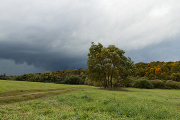 A coming storm with dark clouds in a country side during fall season