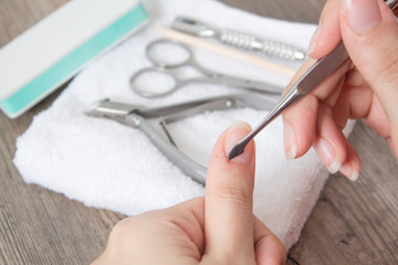 Manicure. Push back the cuticle with a metal pusher. Getting injured during a manicure. Skin care,...