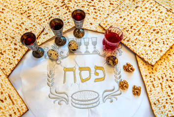 Unleavened bread food - matzah and glass of red wine for Jewish Passover Holiday. White serviette...