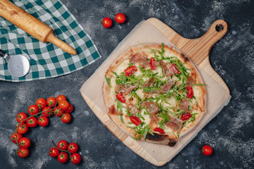 delicious Neapolitan pizza on board with cherry tomatoes, free space for text