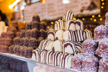 White Chocolate covered marshmallows. Beautiful big pile of delicious pastries. Christmas market food stand, Paris, France. Blurred background.