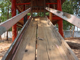 Wooden slider in old playground for children. 