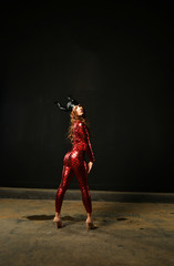 Fototapeta na wymiar sexy girl in a red suit on a black background