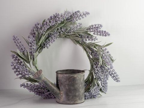 Purple lavender wreath with a rustic metal watering can on a white background.  Simple, elegant, country, home decor.
