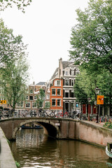 Naklejka premium canal in amsterdam with boats and around old houses