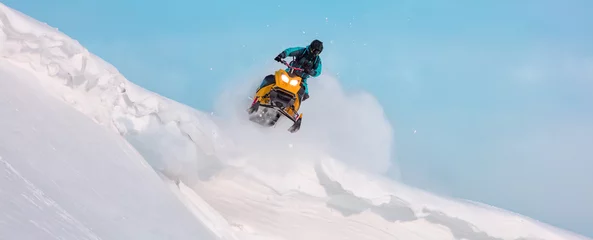 Fotobehang jump and ride in a big avalanche on a snowmobile with snow splashes and a storm. the snowmobiler is testing a new model of mountain snowmobile, the prototype of 2021. Winter FUN extreme © Wlad Go