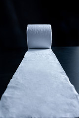 Unrolled toilet paper on dark back ground