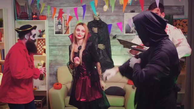 Spooky witch arriving with pizza at halloween party