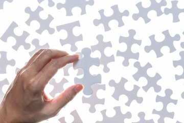 Man hand holding piece of jigsaw