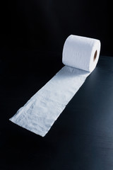 Unrolled toilet paper on dark back ground perspective right view