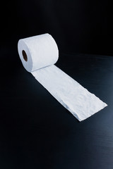 Unrolled toilet paper on dark back ground perspective left view
