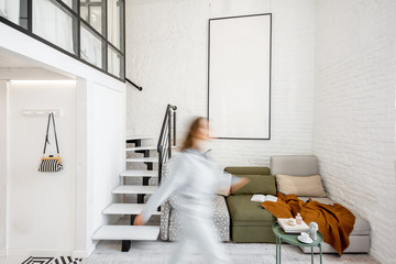 Interior view of the bright modern living room with a blurred in motion human figure