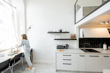 Interior view of the bright and modern kitchen with a blurred in motion human figure