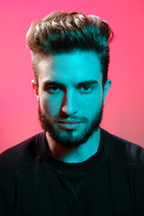 Beautiful caucasian young man portrait isolated on multicolored neon light backgroud. Young, smiling, surprised, screaming. Human emotions, facial expression concept. Trendy colors.Advertising concept