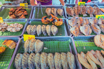 Many kinds of deep fried fish on tray for sale at street food in Thailand.