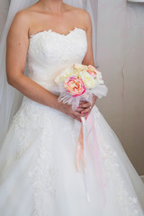 Naklejka premium The bride holds a beautiful wedding bouquet of pink and white flowers in her hands