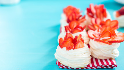 strawberry pavlova topped with fresh cream and strawberries